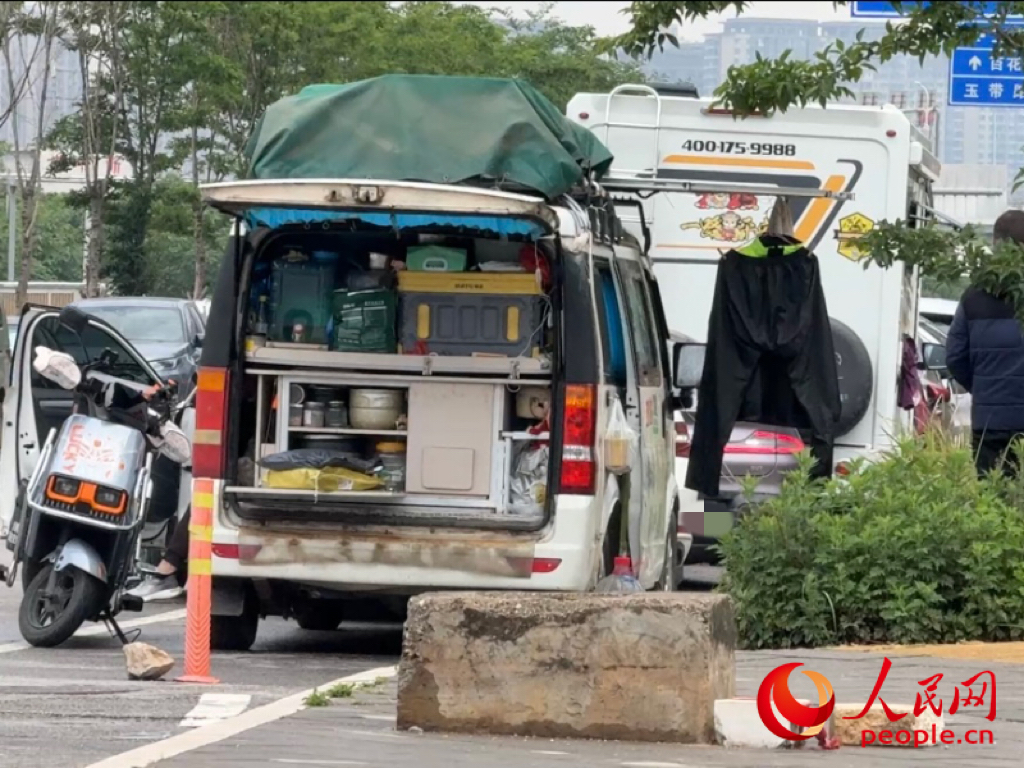 昆明市虾塘路,房车车主在路边晾晒衣物。人民网记者 蔡树菁摄